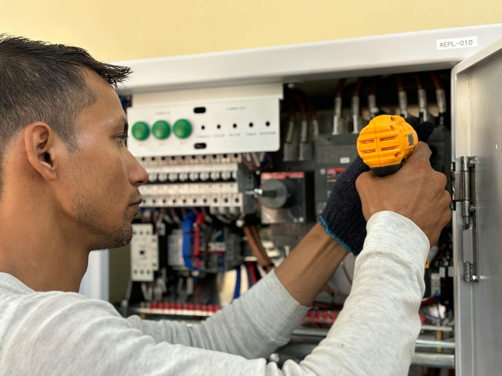 Elektryk wierci młotem SDS przy naprawie instalacji elektrycznej