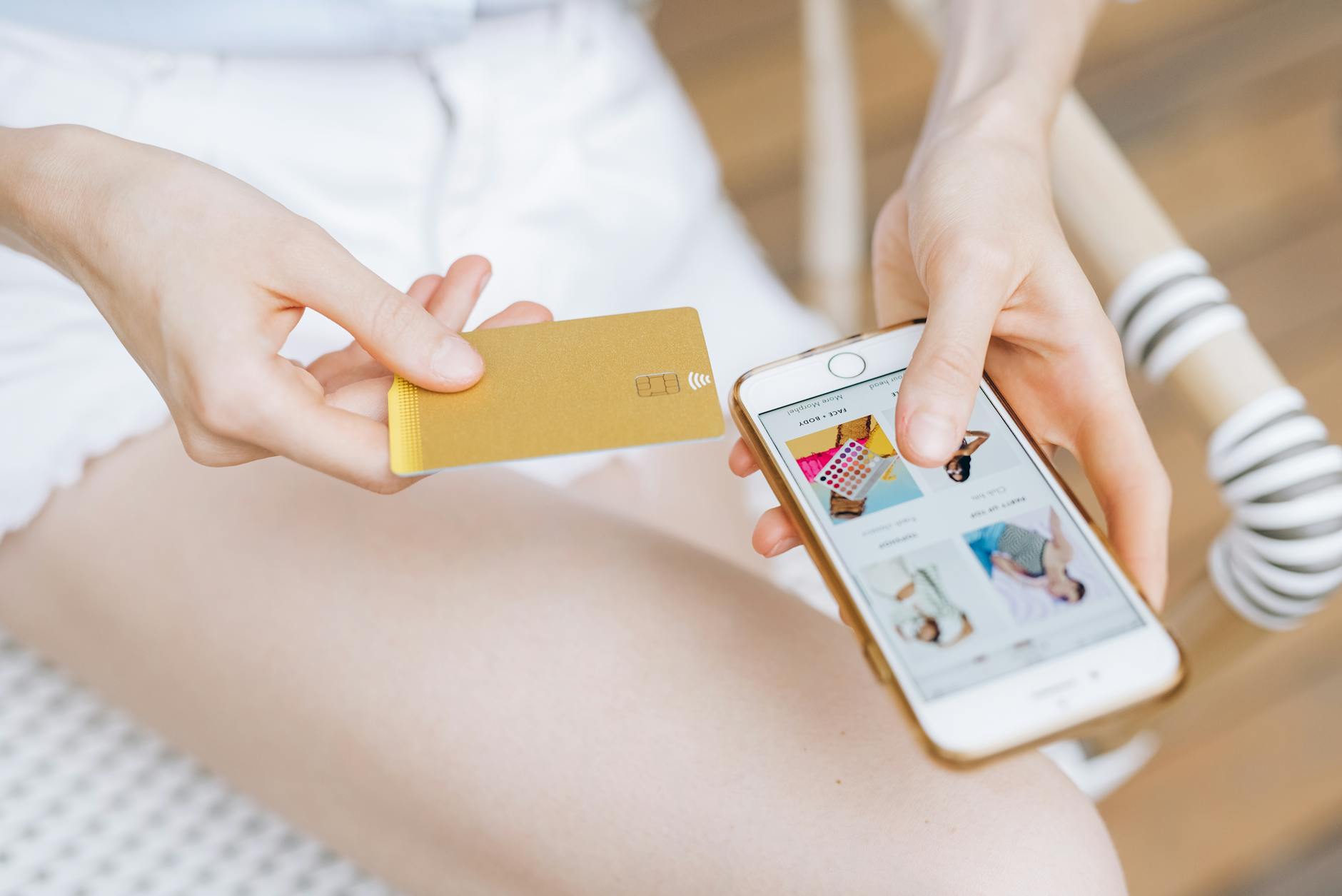 Kobieta trzymająca smartfon i kartę płatniczą podczas zakupów online