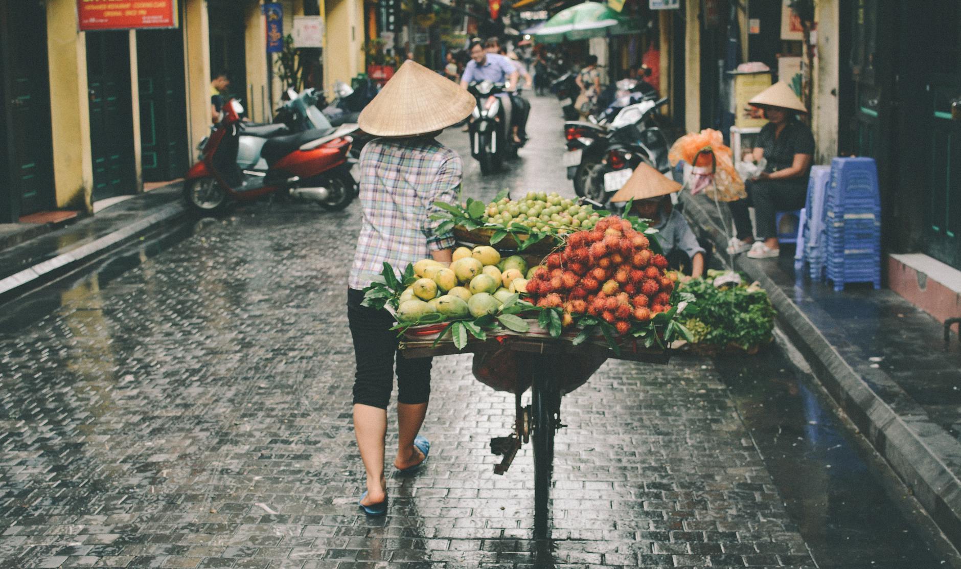 Sprzedawczyni świeżych owoców na ulicznym targu w Hanoi, Wietnam