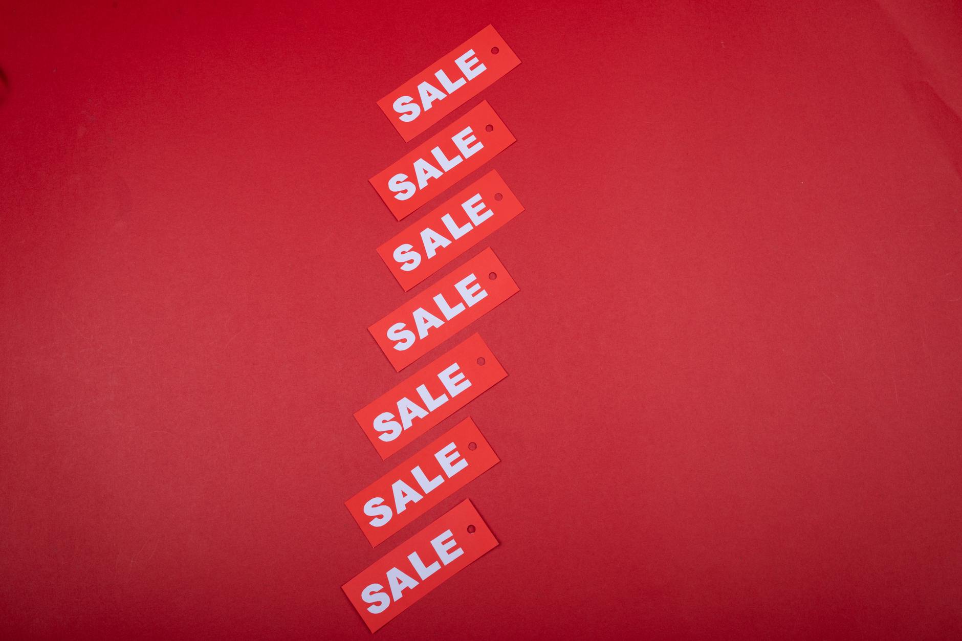 Czerwone metki z napisem sale na czerwonym tle, symbol wyprzedaży