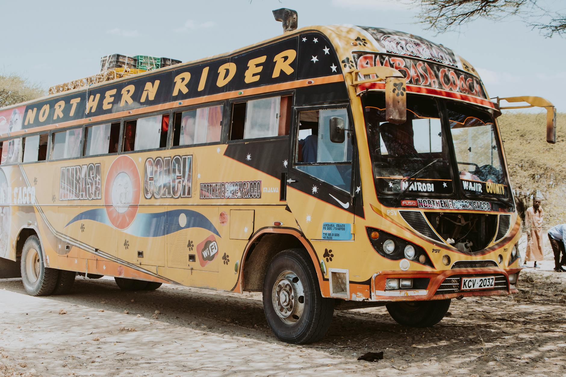 Kolorowy autobus Northern Rider na piaszczystej drodze w kenijskiej wsi