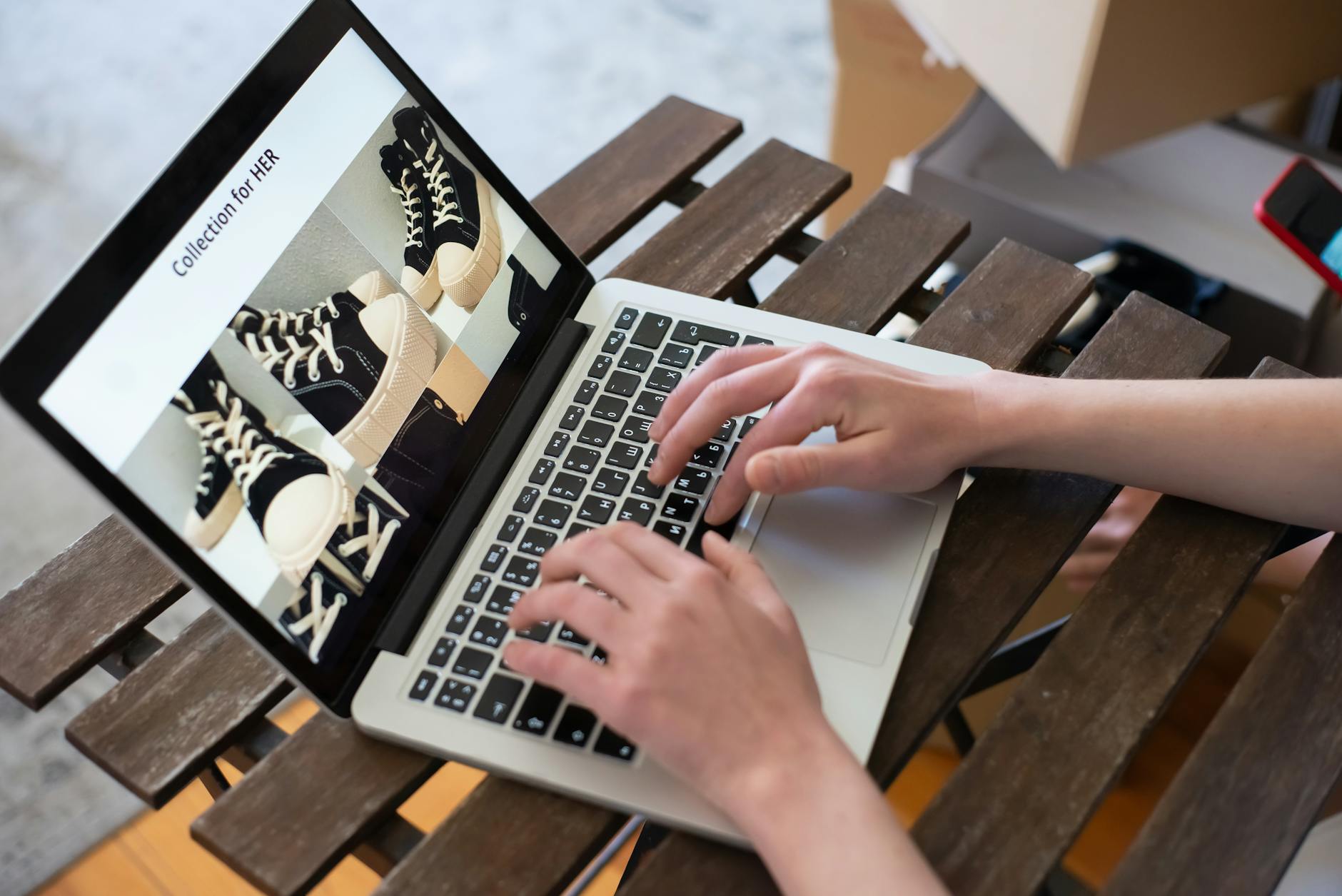 Osoba przegląda internetowy sklep z butami na laptopie