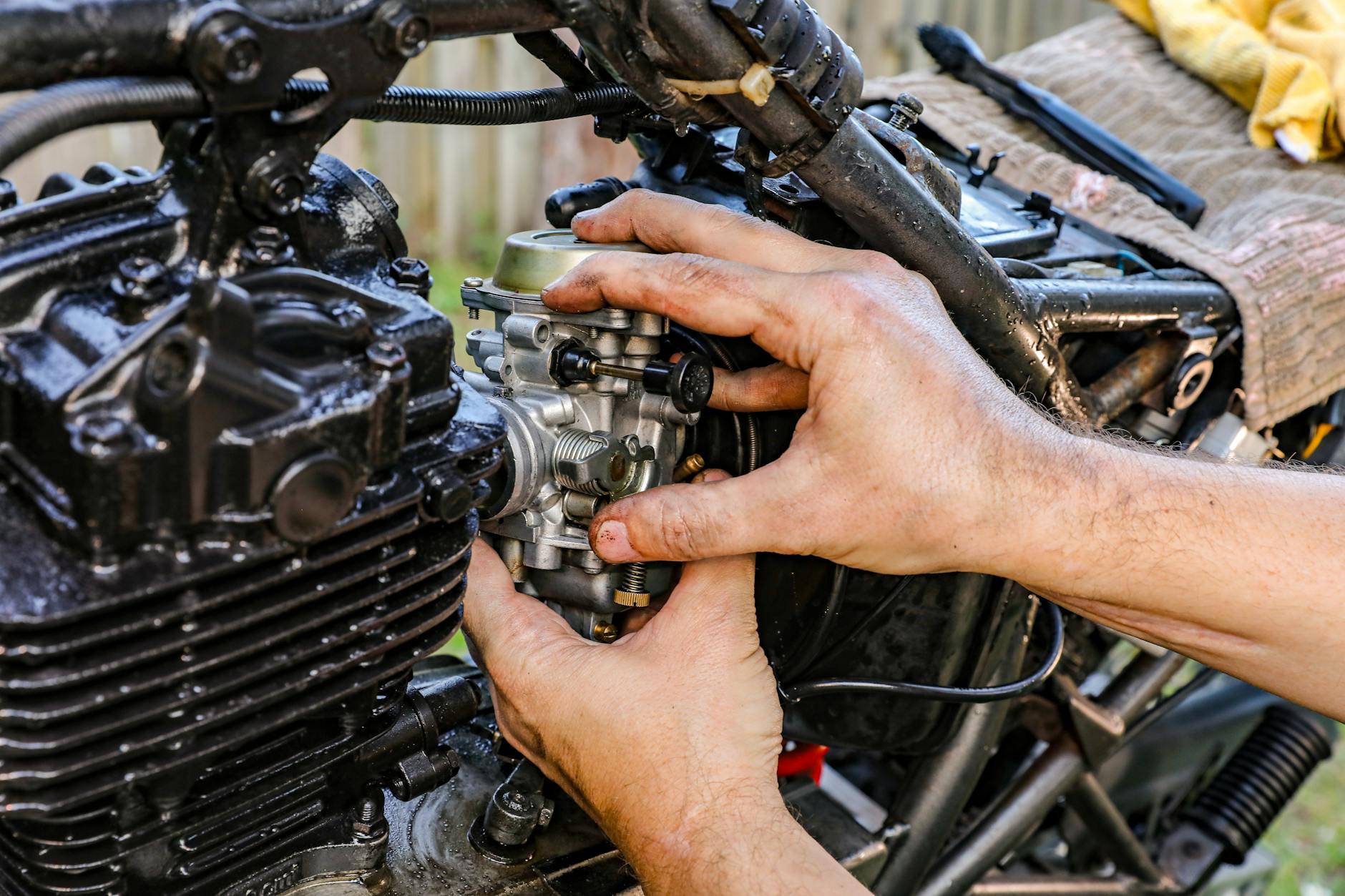 Mechanik na dworze montuje gaźnik małego silnika spalinowego