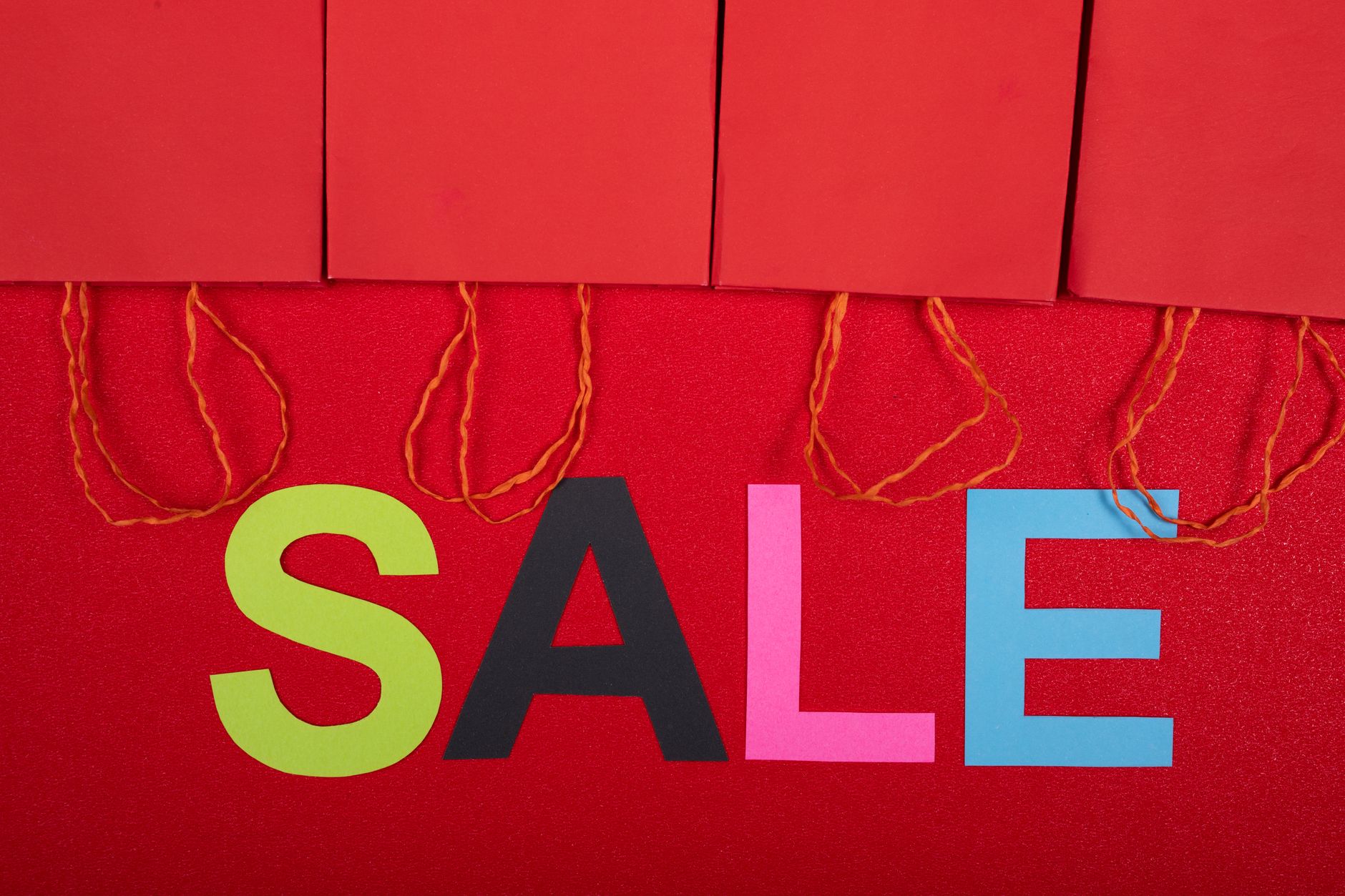 Kolorowy napis sale i czerwone torby zakupowe w sklepie Kolorowy napis sale i czerwone torby zakupowe w sklepie